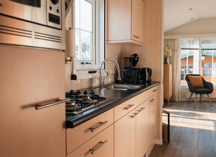 Bright living room in Chalet Bregkoog 24, De Koog, Texel, with comfortable chairs and large windows.