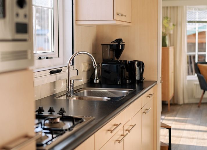 Bright living room in Chalet Bregkoog 24, De Koog, Texel, with comfortable chairs and large windows.