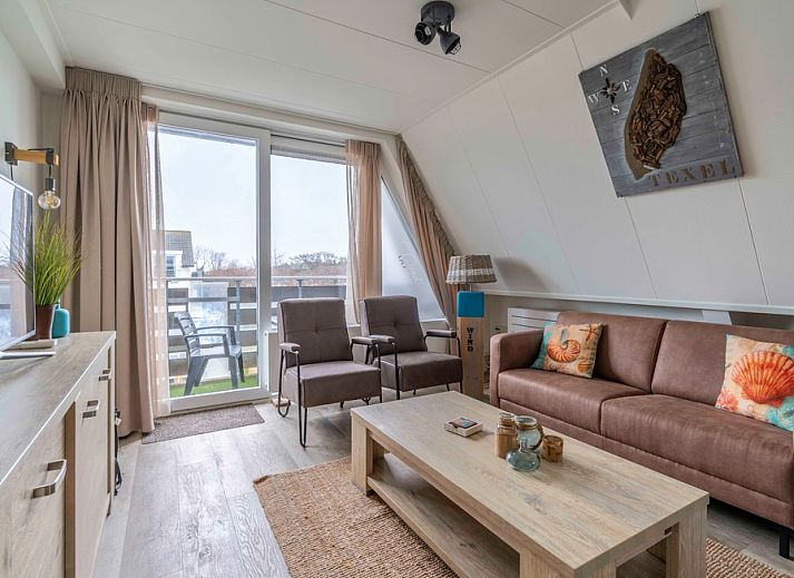 Gemuetliches Wohnzimmer von Apartment Anna 224 in De Koog, Texel mit Blick auf den Balkon.