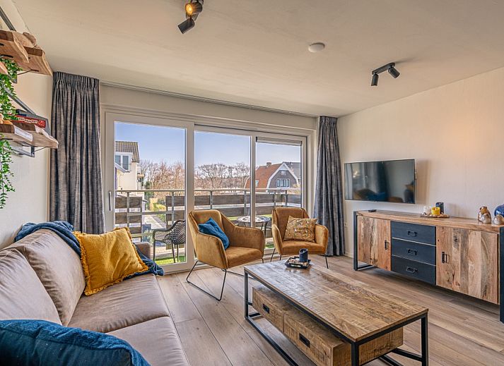 Gemuetliches Wohnzimmer im Appartement Anna 220, De Koog, Texel mit Blick auf Balkon und Natur.