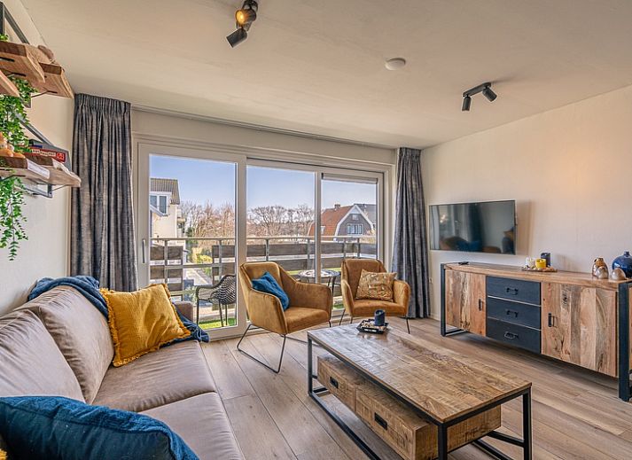 Gemuetliches Wohnzimmer im Appartement Anna 220, De Koog, Texel mit Blick auf Balkon und Natur.