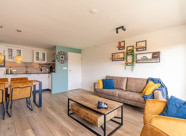 Gemuetliches Wohnzimmer im Appartement Anna 220, De Koog, Texel mit Blick auf Balkon und Natur.