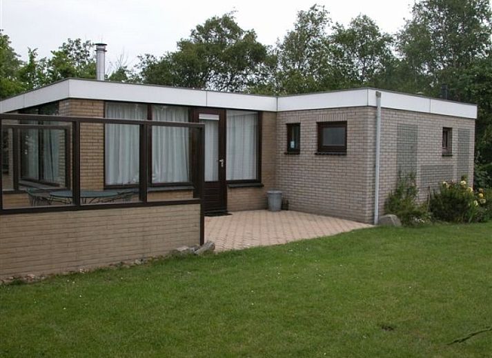 Bungalow Oud Vredelust 75 in De Koog, Texel, surrounded by green nature and flowers.