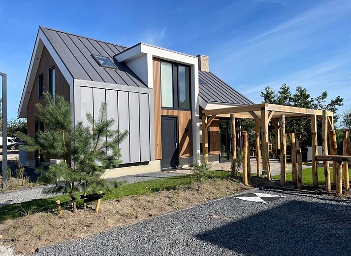 Duinvilla Wellness 5 in De Koog, Texel, modernes Ferienhaus mit Holzfassade und Veranda mitten in der Natur.