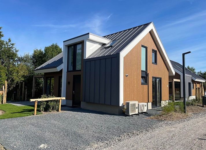 Duinvilla Wellness 5 in De Koog, Texel, modernes Ferienhaus mit Holzfassade und Veranda mitten in der Natur.