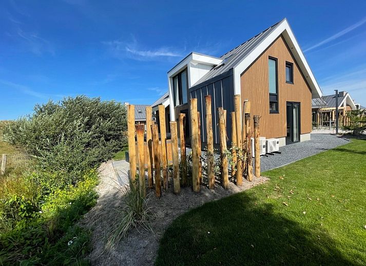 Duinvilla Wellness 5 in De Koog, Texel, modernes Ferienhaus mit Holzfassade und Veranda mitten in der Natur.