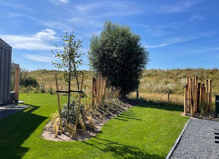 Duinvilla Wellness 5 in De Koog, Texel, modernes Ferienhaus mit Holzfassade und Veranda mitten in der Natur.