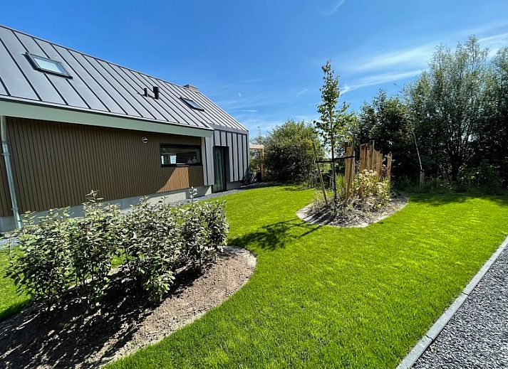 Seitenansicht von Duinvilla Wellness 5 in De Koog, Texel, Ferienhaus mit moderner Architektur und grosser Veranda.