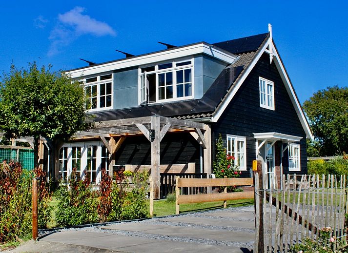 Residence Rustiek vakantiehuis in De Koog, Texel met houten gevel en groene tuin.