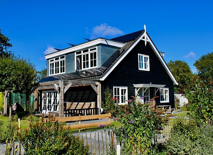 Residence Rustiek vakantiehuis in De Koog, Texel met houten gevel en groene tuin.