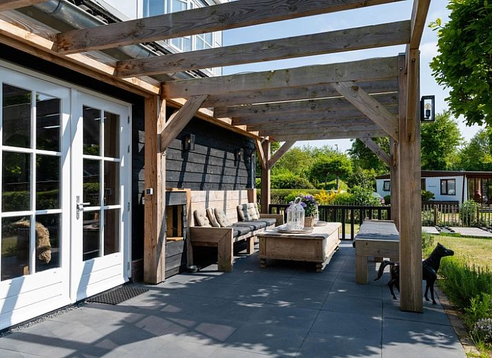 Residence Rustiek vakantiehuis in De Koog, Texel met houten gevel en groene tuin.