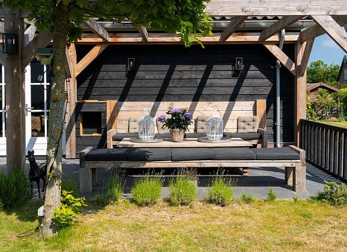 Residence Rustiek vakantiehuis in De Koog, Texel met houten gevel en groene tuin.