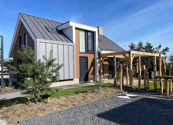 Duinvilla Wellness 6 in De Koog, Texel, modern vacation home with wooden facade and veranda.