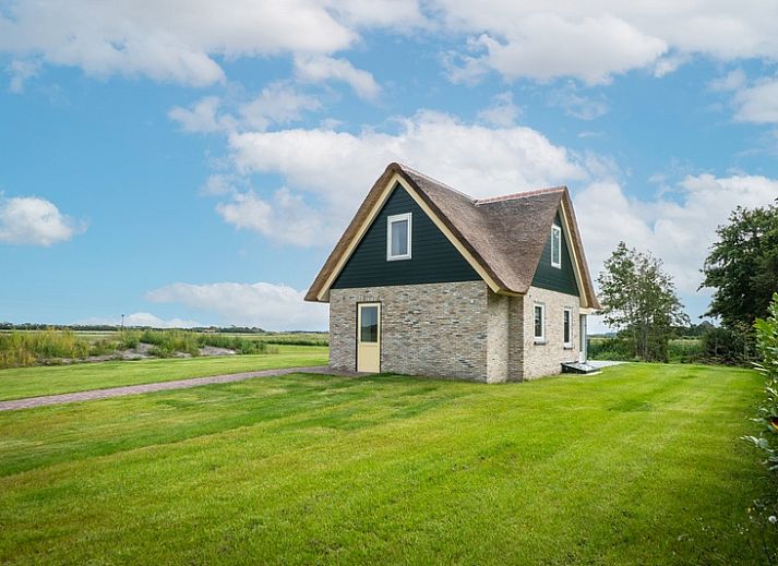 Landhaus-Ferienhaus in De Koog, Texel, mit schoener Aussicht auf die Natur und einen ruhigen Teich.