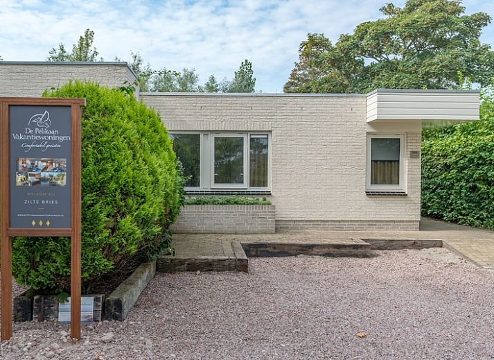 Zilte Bries vakantiehuis met zonnig terras in De Koog, Texel, omringd door groene natuur.