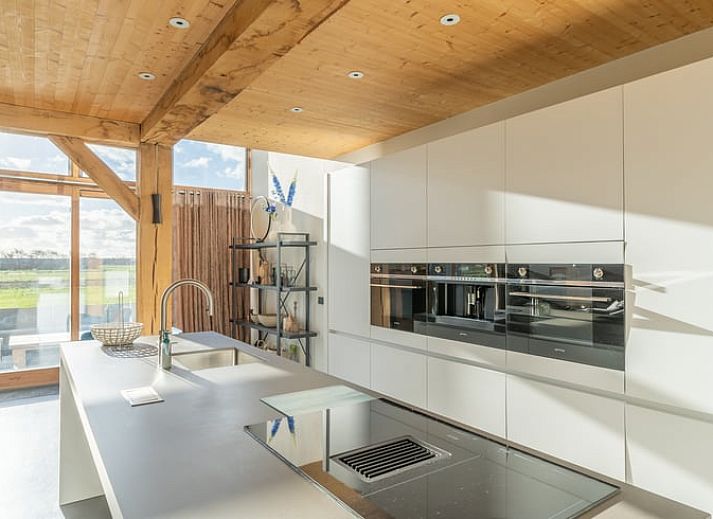 Cozy living room with fireplace in Holiday home in De Koog Texel, offers views of the nature of the Wadden Islands.