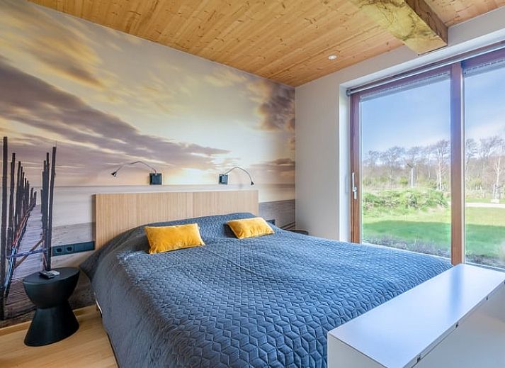 Cozy living room with fireplace in Holiday home in De Koog Texel, offers views of the nature of the Wadden Islands.