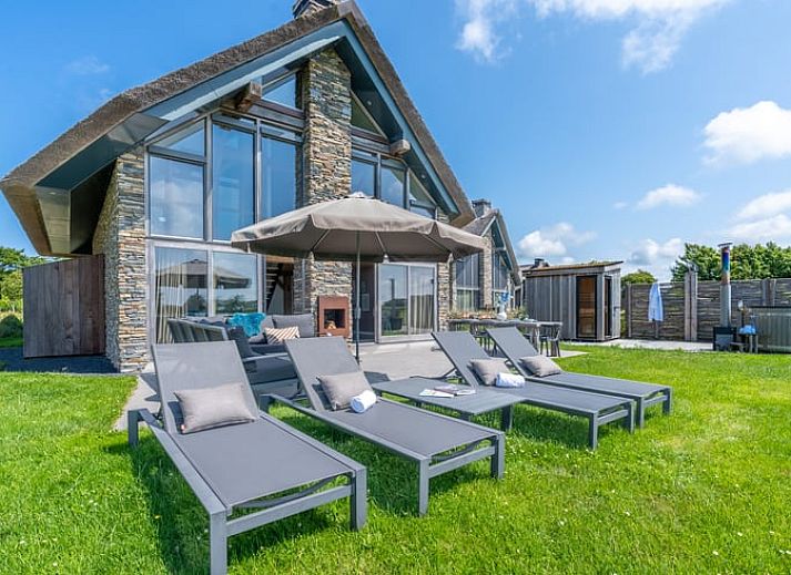 Comfortable sitting area with fireplace in Holiday home in De Koog Texel, overlooking the Wadden Islands garden.