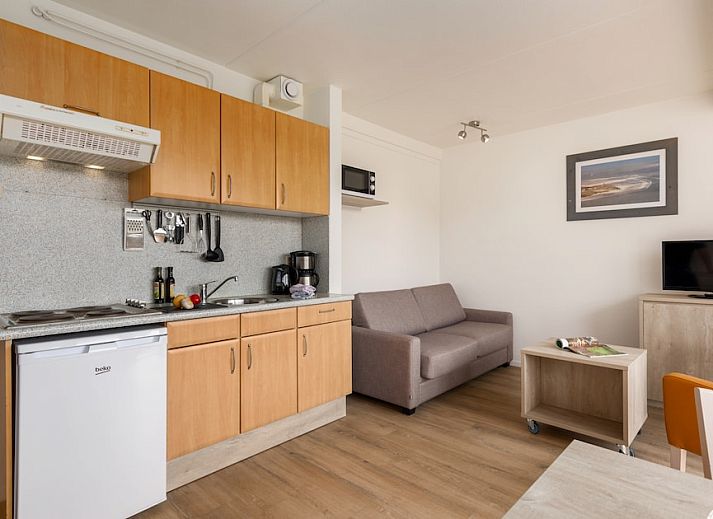 Cozy living room of B Apartment Comfort 4 in De Koog, Texel, with views of nature and an inviting terrace.