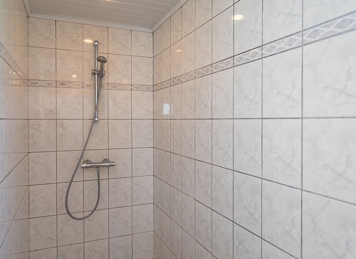 Spacious terrace at Bungalow 2 in De Koog, Texel with comfortable seating surrounded by green nature.