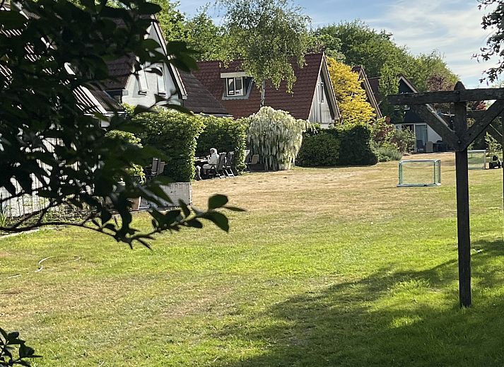 Essecke im Koetshuis 1 Ferienhaus De Koog Texel mit Holztisch und bunten Stuehlen.