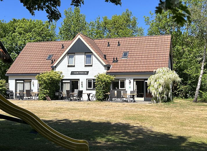 Ferienhaus Koetshuis 2 in De Koog, Texel mit sonniger Terrasse und gruener Umgebung.