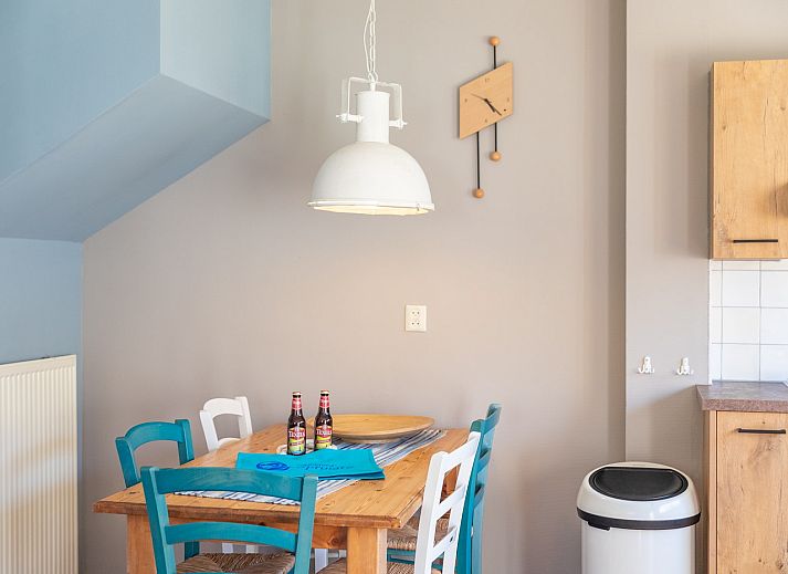 Terrace of Koetshuis 3 vacation home in De Koog, Texel with dining table and green planting.