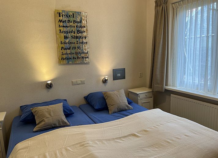 Terrace of Koetshuis 3 vacation home in De Koog, Texel with dining table and green planting.