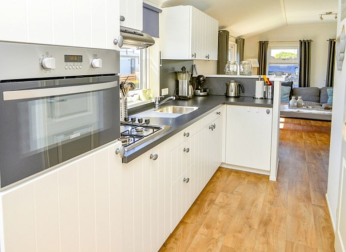 Cozy living room in Chaletpark Bregkoog - Chalet Bregkoog 215 Zandhuisjes, De Koog, Texel, with comfortable sofas and lots of light.