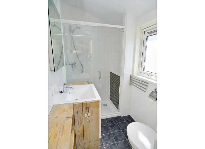 Cozy living room in Chaletpark Bregkoog - Chalet Bregkoog 215 Zandhuisjes, De Koog, Texel, with comfortable sofas and lots of light.