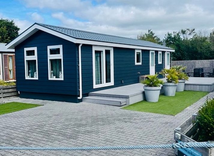 Cozy living room in Chaletpark Bregkoog - Chalet Bregkoog 215 Zandhuisjes, De Koog, Texel, with comfortable sofas and lots of light.