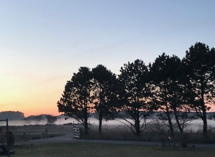Gezellige binnenruimte van Texel Villa Duinzicht in De Koog, Texel met zonlicht en houten vloer.