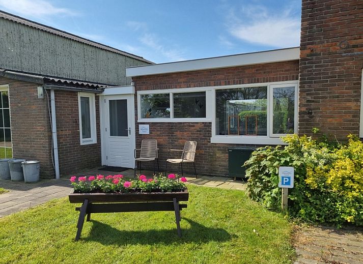 Stiekel Ferienhaus in De Waal, Texel mit gemuetlicher Veranda und Blumengarten.