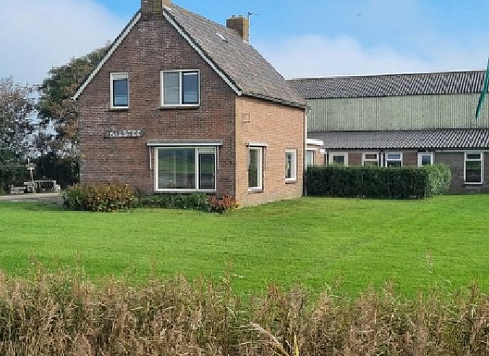 Stiekel Ferienhaus in De Waal, Texel mit gemuetlicher Veranda und Blumengarten.