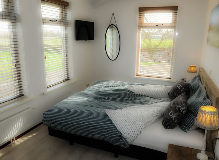 Zijaanzicht van Vakantiehuis 5885 - Eelman de Porto, De Waal, Texel omgeven door groen.