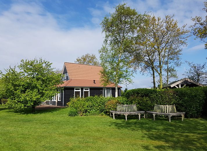 Zijaanzicht van Vakantiehuis 5885 - Eelman de Porto, De Waal, Texel omgeven door groen.
