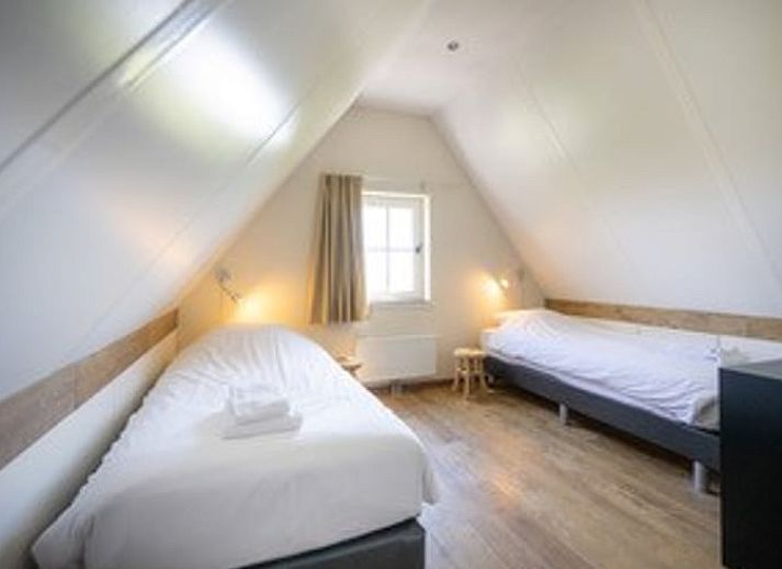 Ruime woonkamer van Huisje in De Waal, Texel, met veel lichtinval en toegang tot het terras.