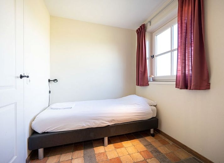 Ruime woonkamer van Huisje in De Waal, Texel, met veel lichtinval en toegang tot het terras.