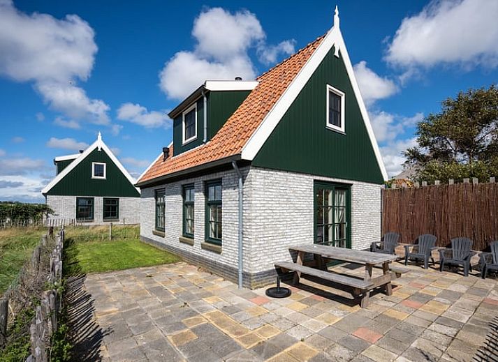 Ruime woonkamer van Huisje in De Waal, Texel, met veel lichtinval en toegang tot het terras.
