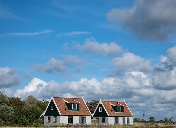 Ruime woonkamer van Huisje in De Waal, Texel, met veel lichtinval en toegang tot het terras.