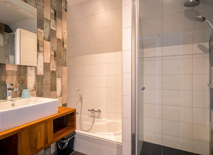 Stilvolle Sitzecke im Ferienhaus in De Waal, Texel mit moderner Einrichtung und Flachbildfernseher zur Entspannung.