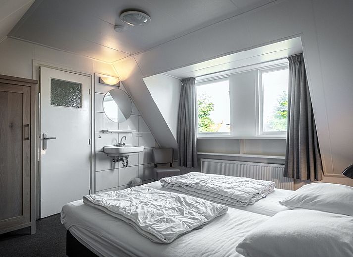 Ferienhaus De Heggemus in Den Burg, Texel, charmante Fassade mit ueppigem Garten.