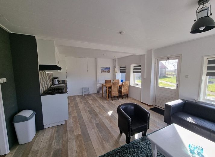 Aussenansicht des Ferienhauses Weidezicht in Den Burg, Texel mit sonniger Terrasse und gruener Umgebung auf den Watteninseln.