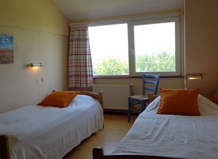 Aussenansicht des Ferienhauses Weidezicht in Den Burg, Texel mit sonniger Terrasse und gruener Umgebung auf den Watteninseln.