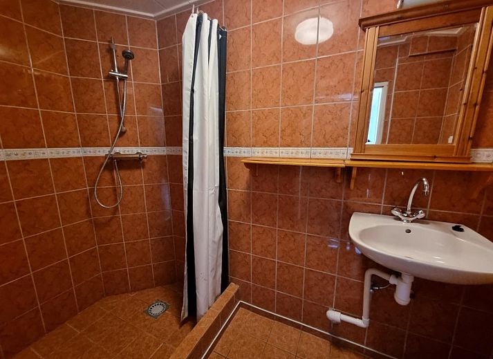 Aussenansicht des Ferienhauses Weidezicht in Den Burg, Texel mit sonniger Terrasse und gruener Umgebung auf den Watteninseln.