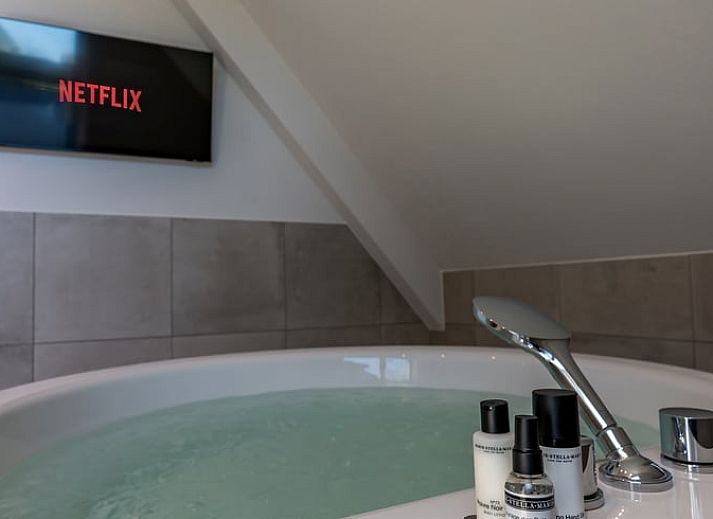 Elektroladestation am Ferienhaus in Den Burg, Texel, in gruener Umgebung.