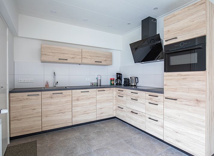 Eingang zum Ferienhaus Schoonoord in Den Burg, Texel, mit charmanter Architektur und gruener Umgebung.