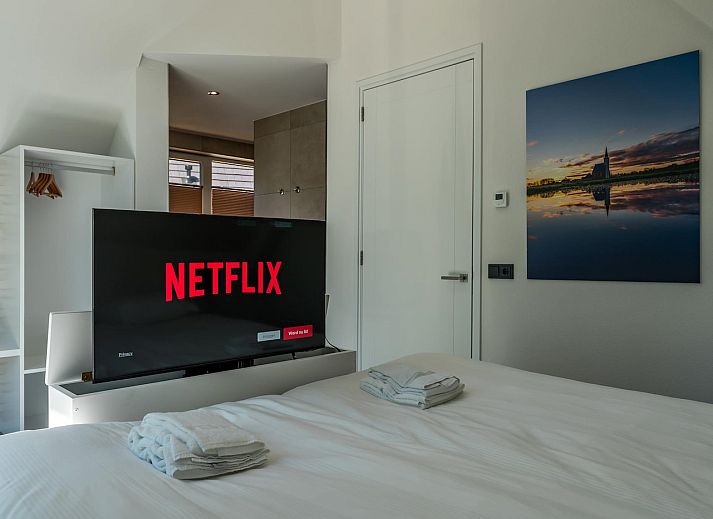 Stilvolles Wohnzimmer im Ferienhaus Bruine Kiekendief, Den Burg Texel, mit Essbereich und Gartenblick.