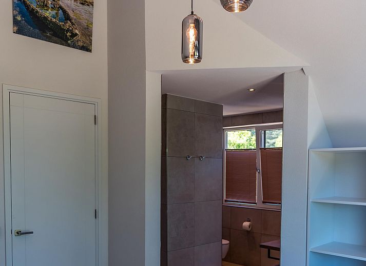 Stilvolles Wohnzimmer im Ferienhaus Bruine Kiekendief, Den Burg Texel, mit Essbereich und Gartenblick.