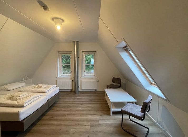 Cozy living room of Cottage in Den Burg, Texel with comfortable seating area and large windows.